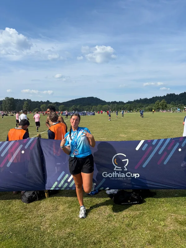 Mia in tournament kit in front of a Gothia Cup pitchside banner