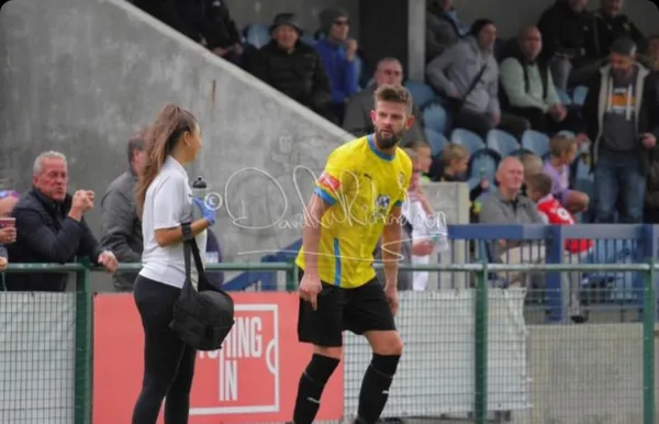 Mia carrying the medical bag along the touchline as a Sporting Khalsa player warms up