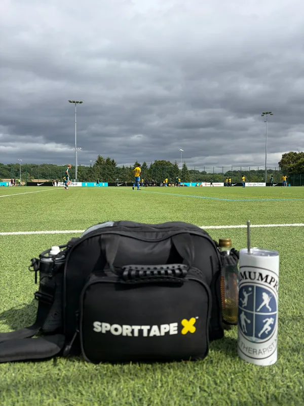 A packed Sporttape kit bag and water bottle waiting on the touchline before kick-off