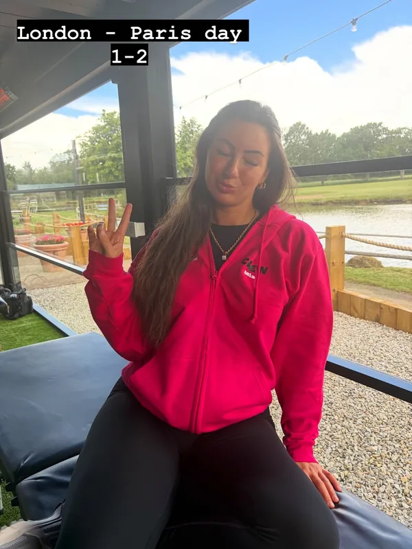 Mia in a pink Cure Leukaemia crew hoodie sat on a treatment couch