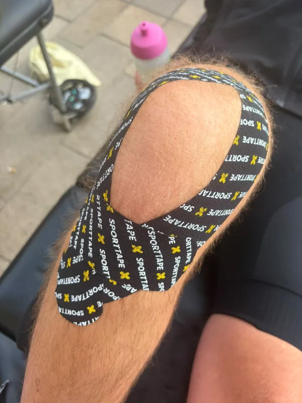 Patterned kinesiology tape fanned across a client's knee